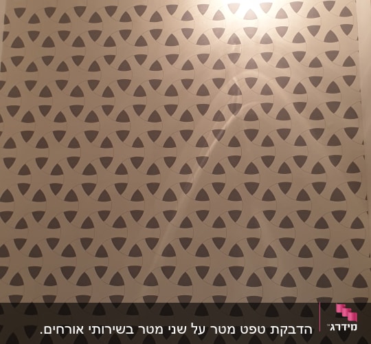 קיר מעוצב המחופה בטפט גאומטרי מעל כיור מונח ותאורת קיר